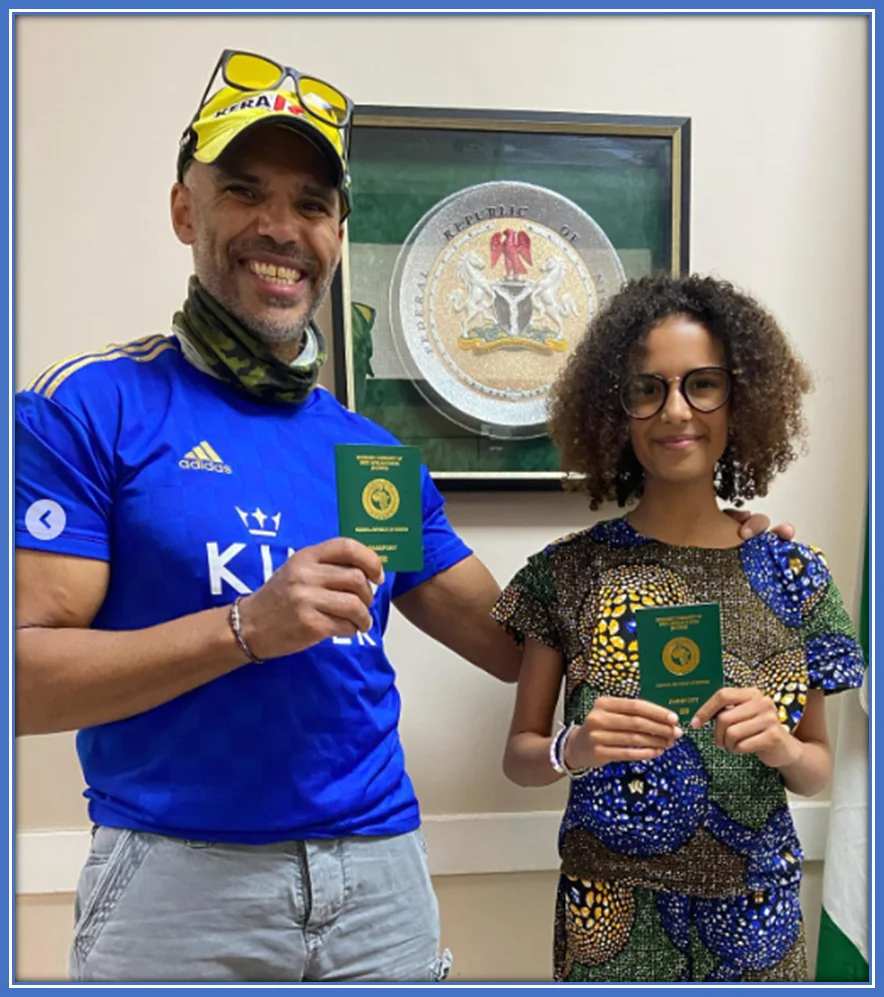 A pix of Ashleigh Plumptre's dad, Tim with her younger sister, Bisi flaunting their Nigerian passport. Credit: Instagram/ashleighhplumptre.