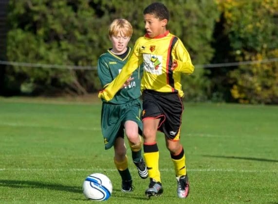 A young Jadon Sancho electrifies the pitch with his raw talent and boundless energy, leaving his opponent behind in awe.