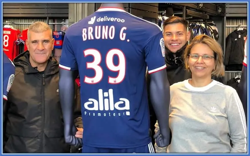 The parents of Bruno Guimarães were feeling excited about their son playing in Europe. They both stand at the sides of their family's pride - the number 39 shirt.