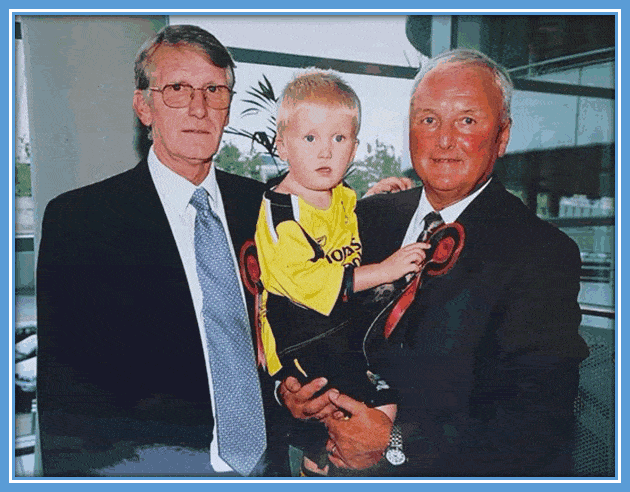 Glyn Pardoe holds little Tommy and together with Mike Doyle, they look at the camera. Picture: Twitter/tommy_doyle8