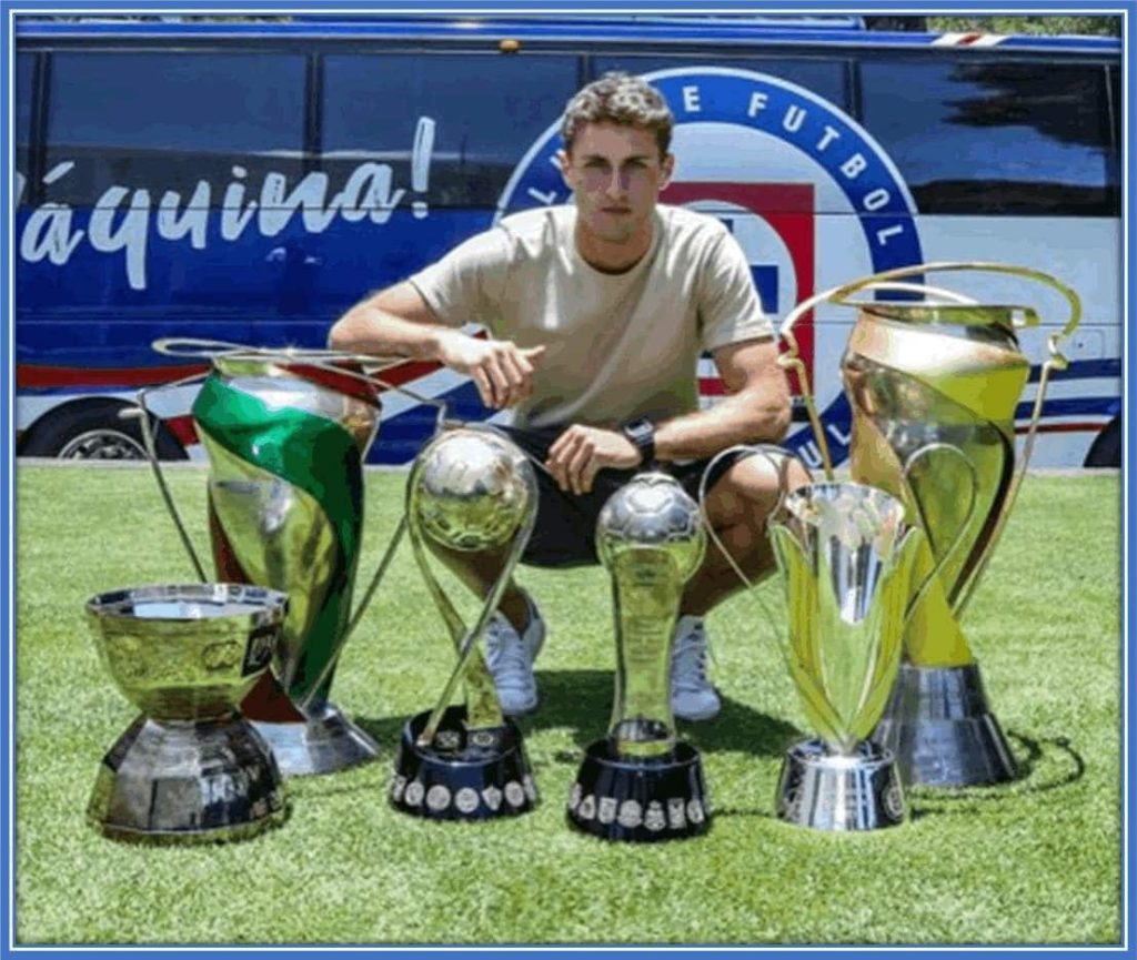 Santiago in a photo with an array of some of his awards.
