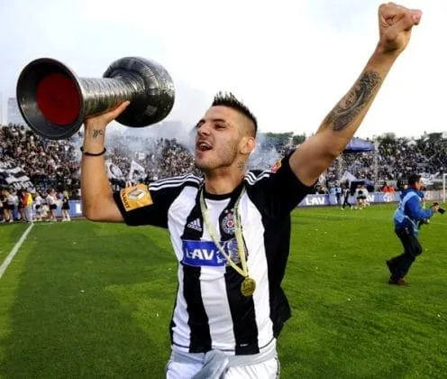 Aleksandar Mitrovic, in his youth, lifts a trophy. He has led his team to victories since his early career years.