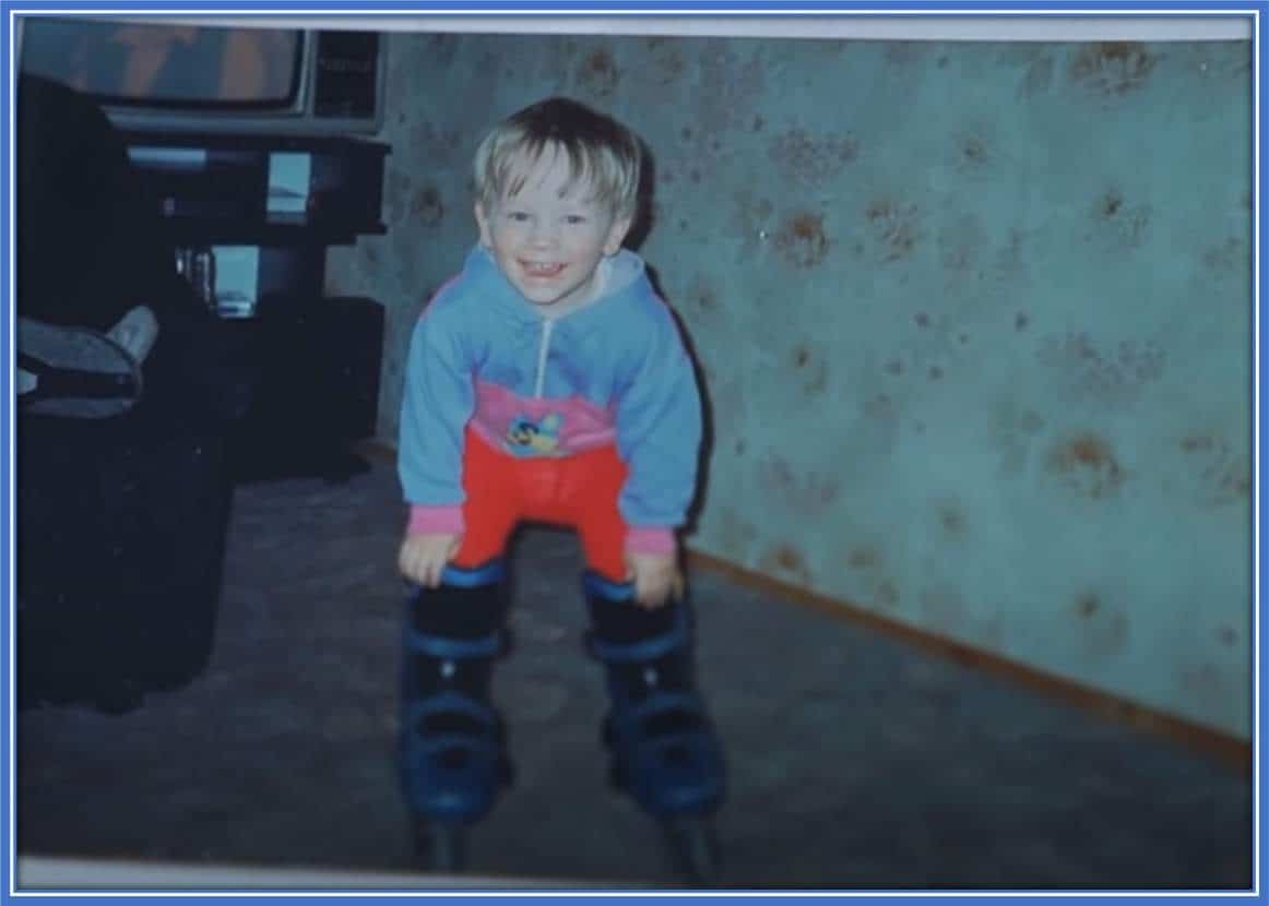 An excited Piotr poses for the camera in his snow shoes right inside his family's living room.