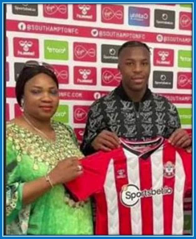 Mrs. Bella Florent Stands Beside her son as he signs into Southampton.