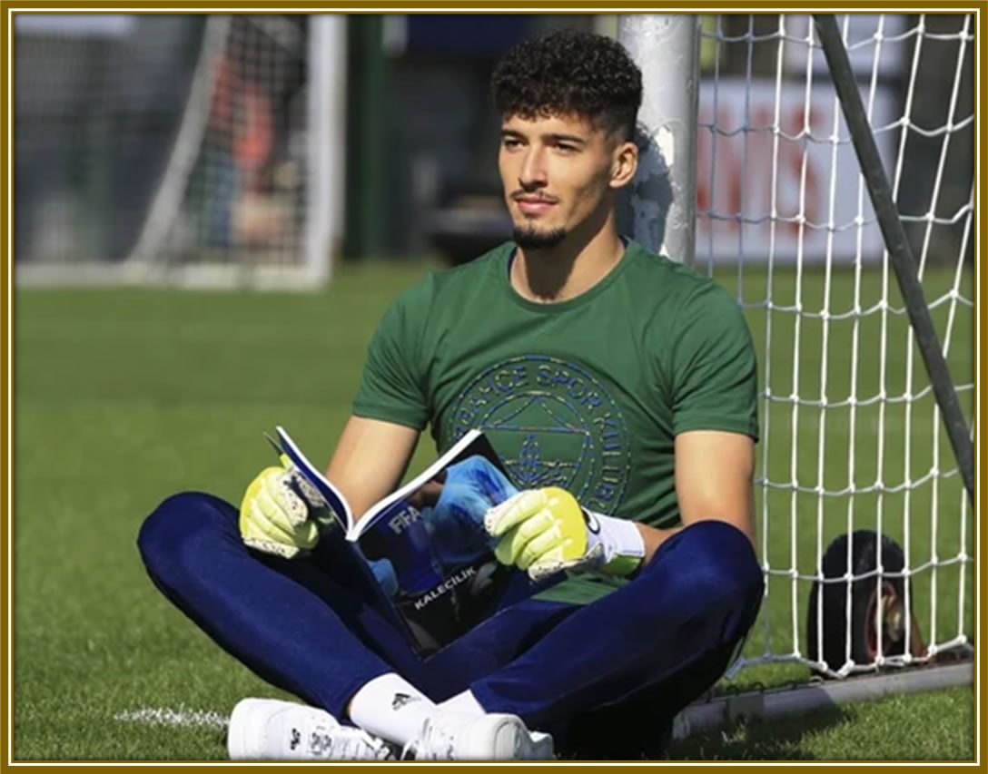 Lost in the pages of the beautiful game. Here, Altay Bayındır dives into FIFA wisdom right after a training session. Image Credit: Ensonhaber.