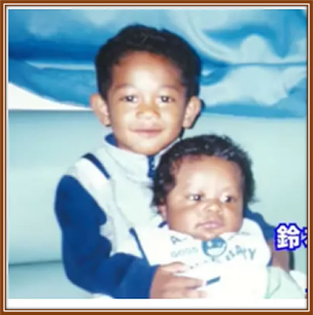 Behold the young Zion Suzuki in the arms of his older brother