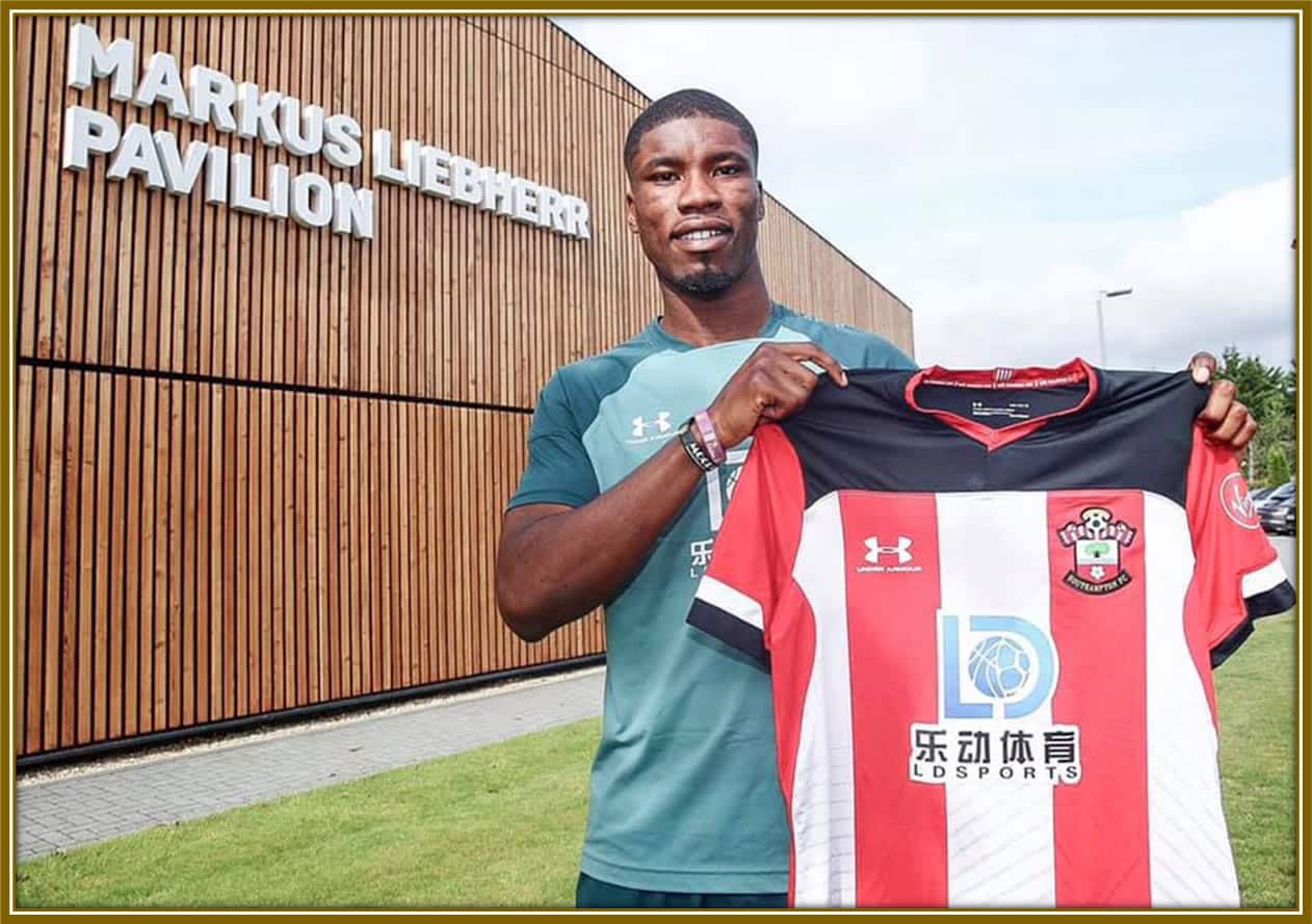 Kevin Danso holds up the Southampton jersey with pride after signing for the Premier League club.